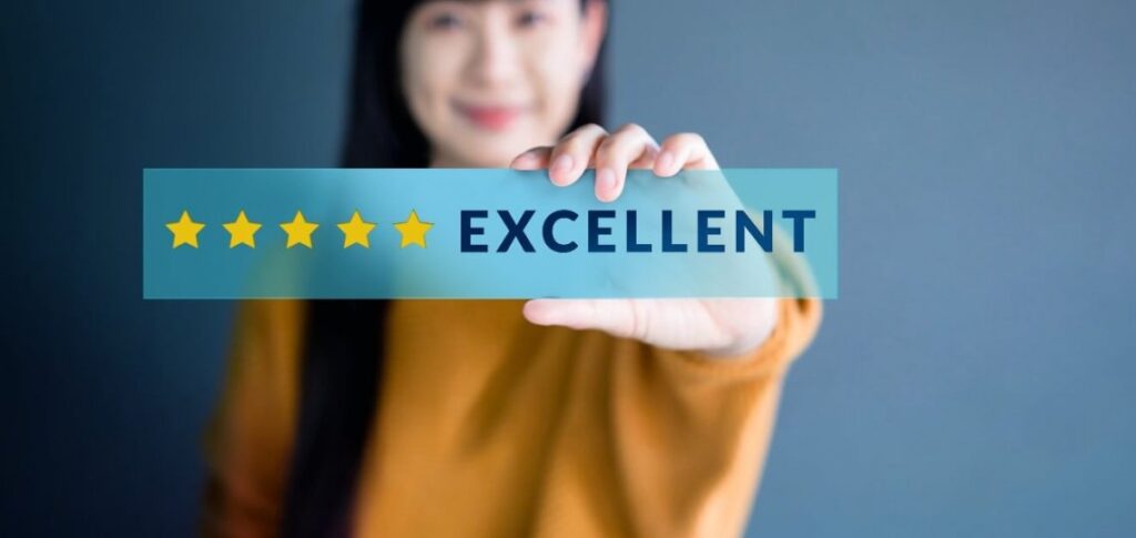 boost-professional-reputation-ebccoaching Person holding a blue card with a five-star rating and the word 'EXCELLENT'.