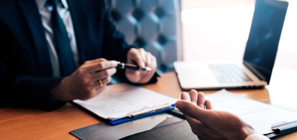 five-ways-to-reconnect-to-career-passion-ebccoaching Two people discussing documents at a desk, one holding a pen.