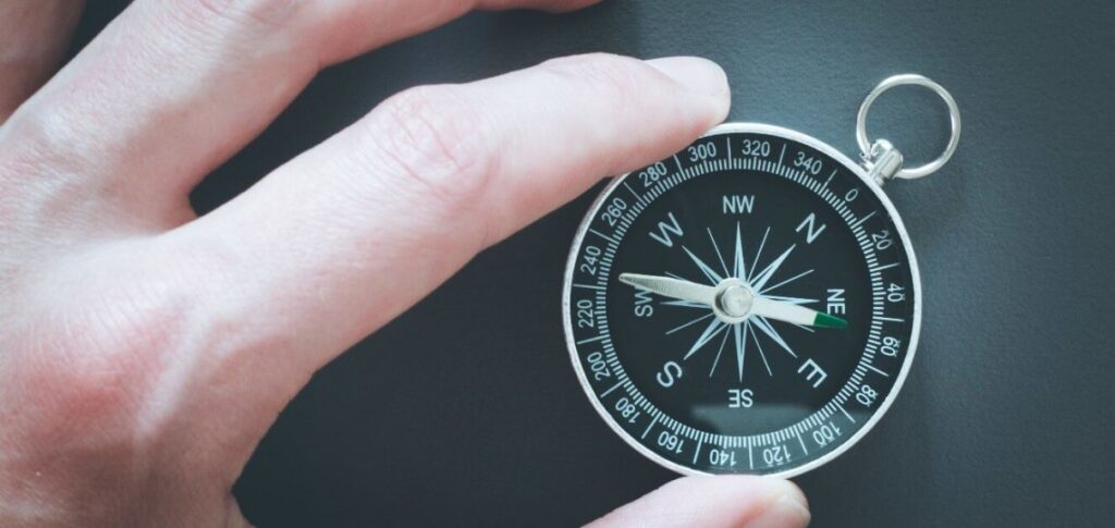 future-proofing-your-professional-life-ebccoaching Hand holding a black and white compass showing directions.